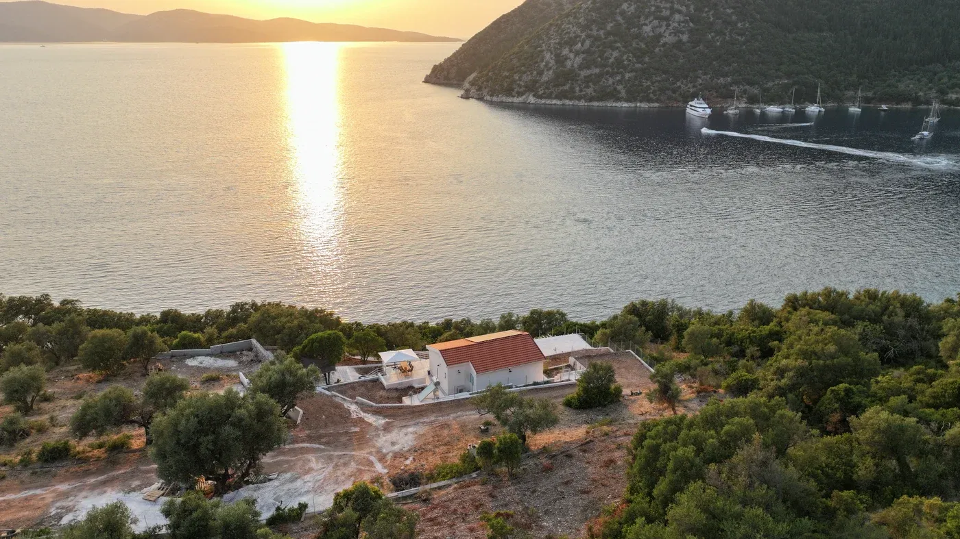 The house on a wooded hillside above the sea in northern Ithaki, seen from the water